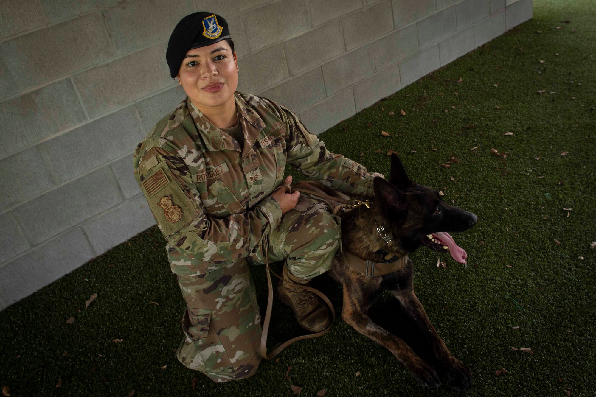 Photo of an Airman posing with a military working dog.