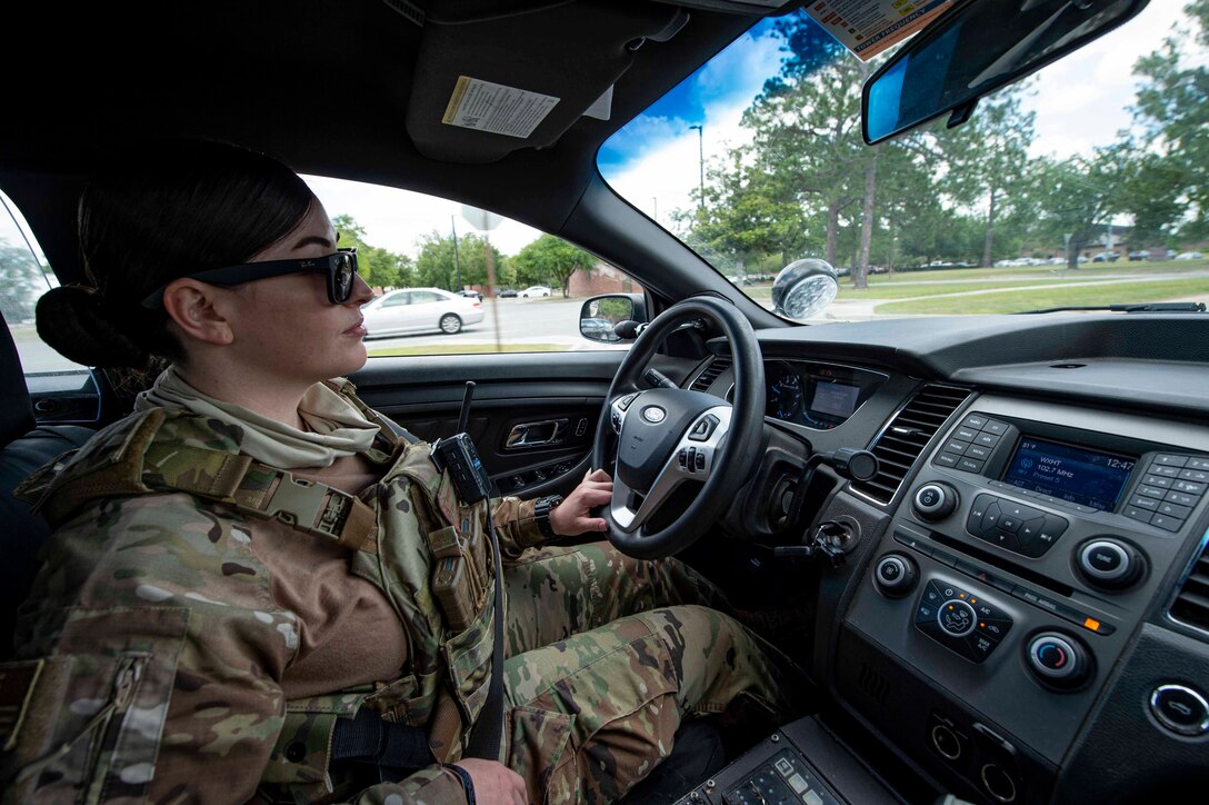 Photo of an Airman driving a patrol car.