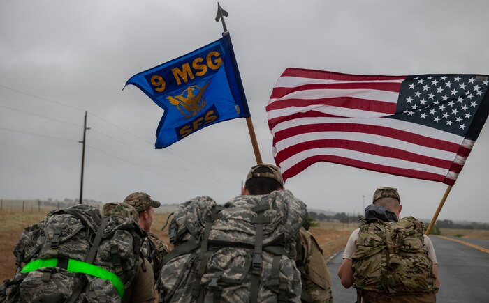 Airmen from the 9th Security Forces Squadron carry a U.S. flag as well as their squadron guidon.