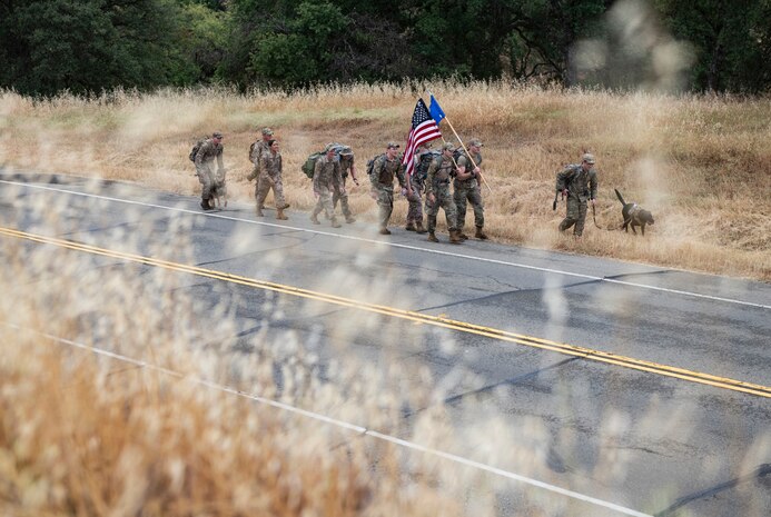 Airmen from the 9th Security Forces Squadron ruck alongside a road as part of Police Week.