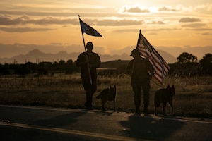 U.S. Air Force Staff Sgt. Sandra Ohfa-Jones, 9th Security Forces Squadron (SFS) trainer, right, and Tech. Sgt. Patrick Harris, 9th SFS commercial vehicle inspection area NCOIC, left, carry the U.S. Flag and 9th SFS guidon as part of Police Week.