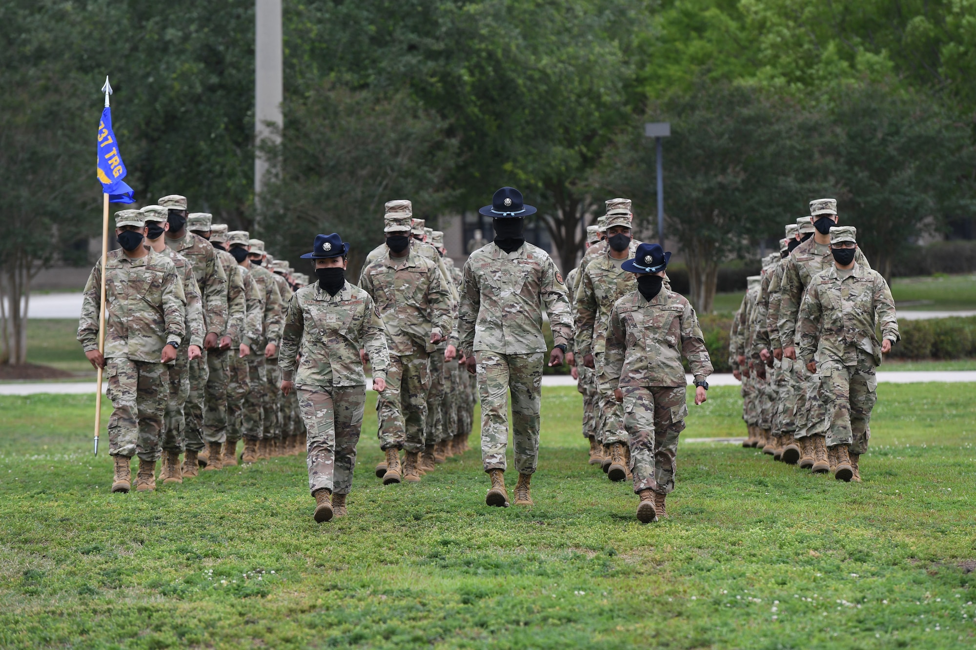 Military training instructors lead graduating Airmen onto the drill pad during the basic military training graduation ceremony at Keesler Air Force Base, Mississippi, May 15, 2020. Nearly 60 Airmen from the 37th Training Wing Detachment 5 completed the six-week basic military training course. Due to safety concerns stemming from COVID-19, the Air Force sent new recruits to Keesler to demonstrate a proof of concept to generate the force at multiple locations during contingencies. The flight was the first to graduate BMT at Keesler since 1968. (U.S. Air Force photo by Kemberly Groue)