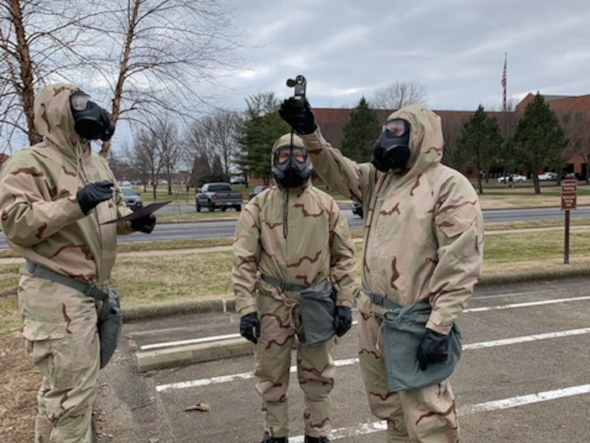 Airmen in protective gear taking weather readings.