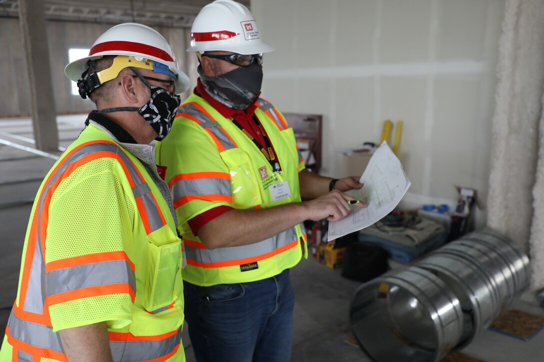 Ryan Field, left, project manager, and Jeremy Ayala, construction representative, both with the U.S. Army Corps of Engineers, Omaha, District, compare the plans May 12, for what will be an alternate care facility in Kalispell, Mont., to the progress made on day two of construction. The state of Montana requested FEMA to task the U.S. Army Corps of Engineers, Omaha District, to build the ACF on the vacant, undeveloped, third floor of Montana Children’s, the new pediatric facility of the Kalispell Regional Medical Center. The temporary facility would accommodate non-acute patients in case Montana faces an increase in COVID-19 patients in the fall. When completed, the ACF will have 98 patient care rooms, seven nurse’s station, four restrooms, three pharmacies and a medical supply storage room.