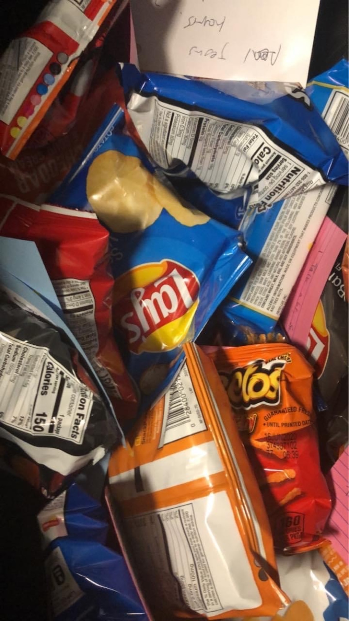 Photo shows a close up of various bags of potato chips and an envelop with a handwritten letter.