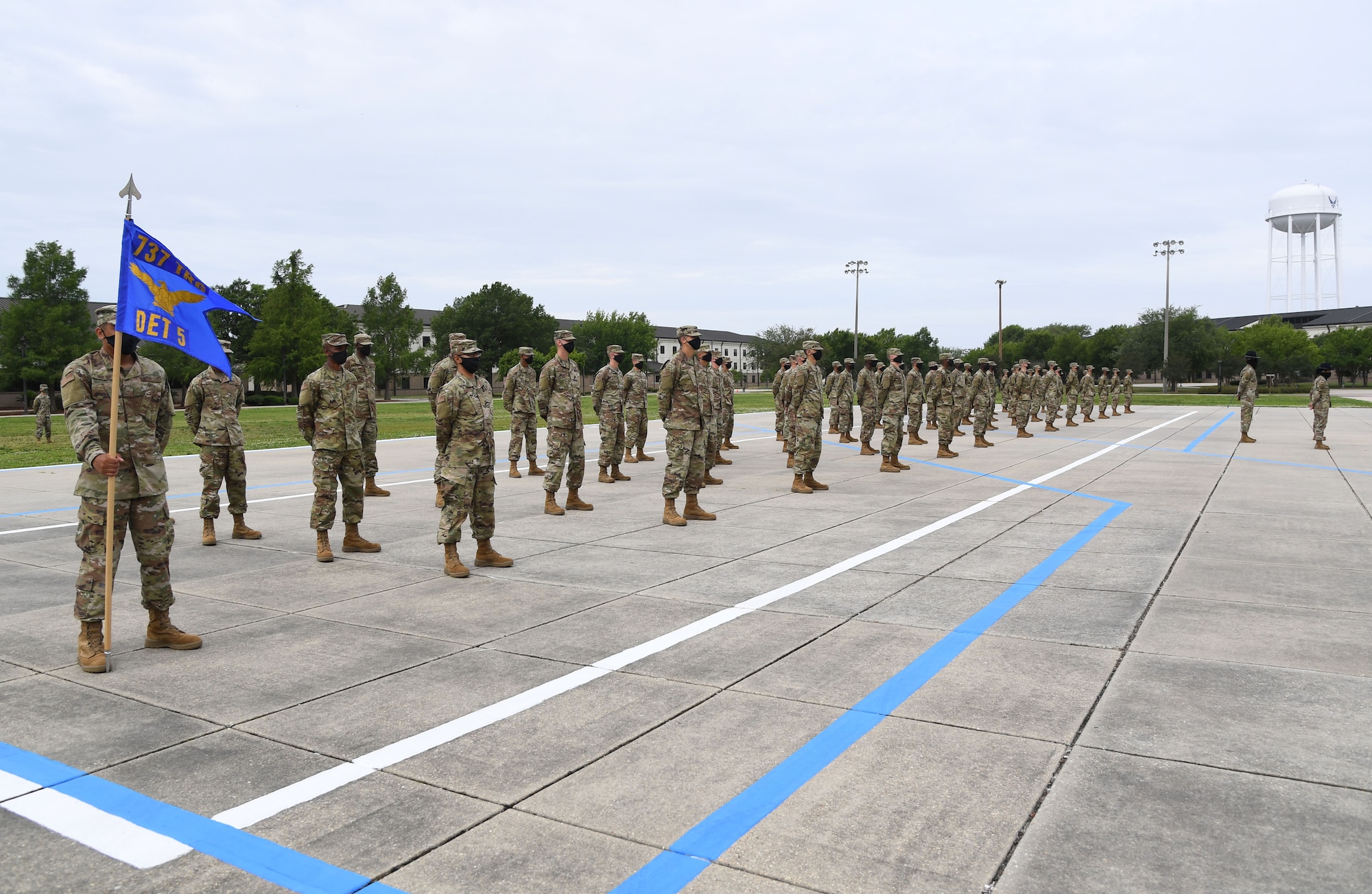 Graduating Airmen stand in formation on the drill pad during the basic military training graduation ceremony at Keesler Air Force Base, Mississippi, May 15, 2020. Nearly 60 Airmen from the 37th Training Wing Detachment 5 completed the six-week basic military training course. Due to safety concerns stemming from COVID-19, the Air Force sent new recruits to Keesler to demonstrate a proof of concept to generate the force at multiple locations during contingencies. The flight was the first to graduate BMT at Keesler since 1968. (U.S. Air Force photo by Kemberly Groue)
