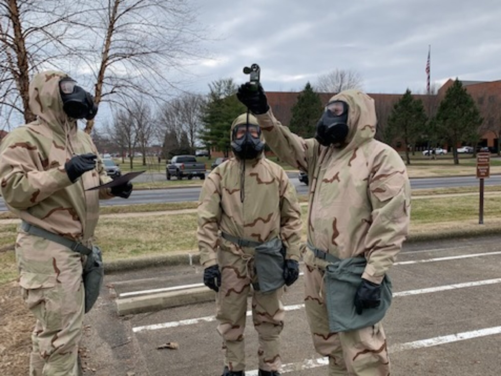 Airmen in protective gear taking weather readings.