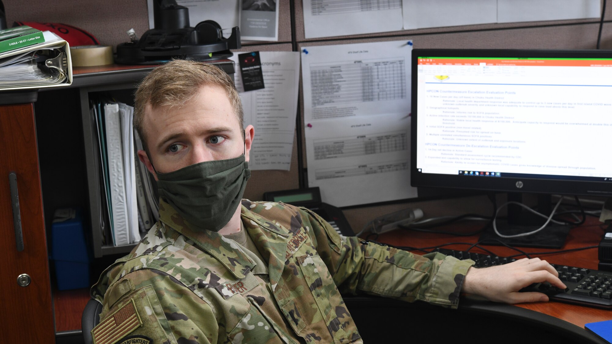 U.S. Air Force 1st Lt. Kristopher Fortier, Future Operations installation cell lead from the 18th Operations Group, conducts data analysis with his team at an emergency operations center, May 6, 2020, at Kadena Air Base, Japan. Fortier, along with other members of FUOPS ensures 18th Wing leaders have a variety of well-thought-out solutions to potential scenarios that may impact Kadena AB during the COVID-19 pandemic. (U.S. Air Force photo by Staff Sgt. Kristan Campbell)
