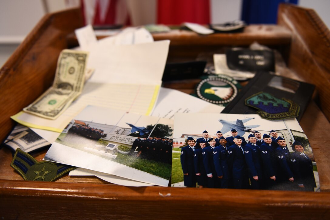Various items are displayed on top of a time capsule at Aviano Air Base, Italy, May 15, 2020. The 31st Logistics Readiness Squadron found the time capsules constructed by the class of 99-A Aviano Airman Leadership School. (U.S. Air Force photo by Airman 1st Class Ericka A. Woolever)