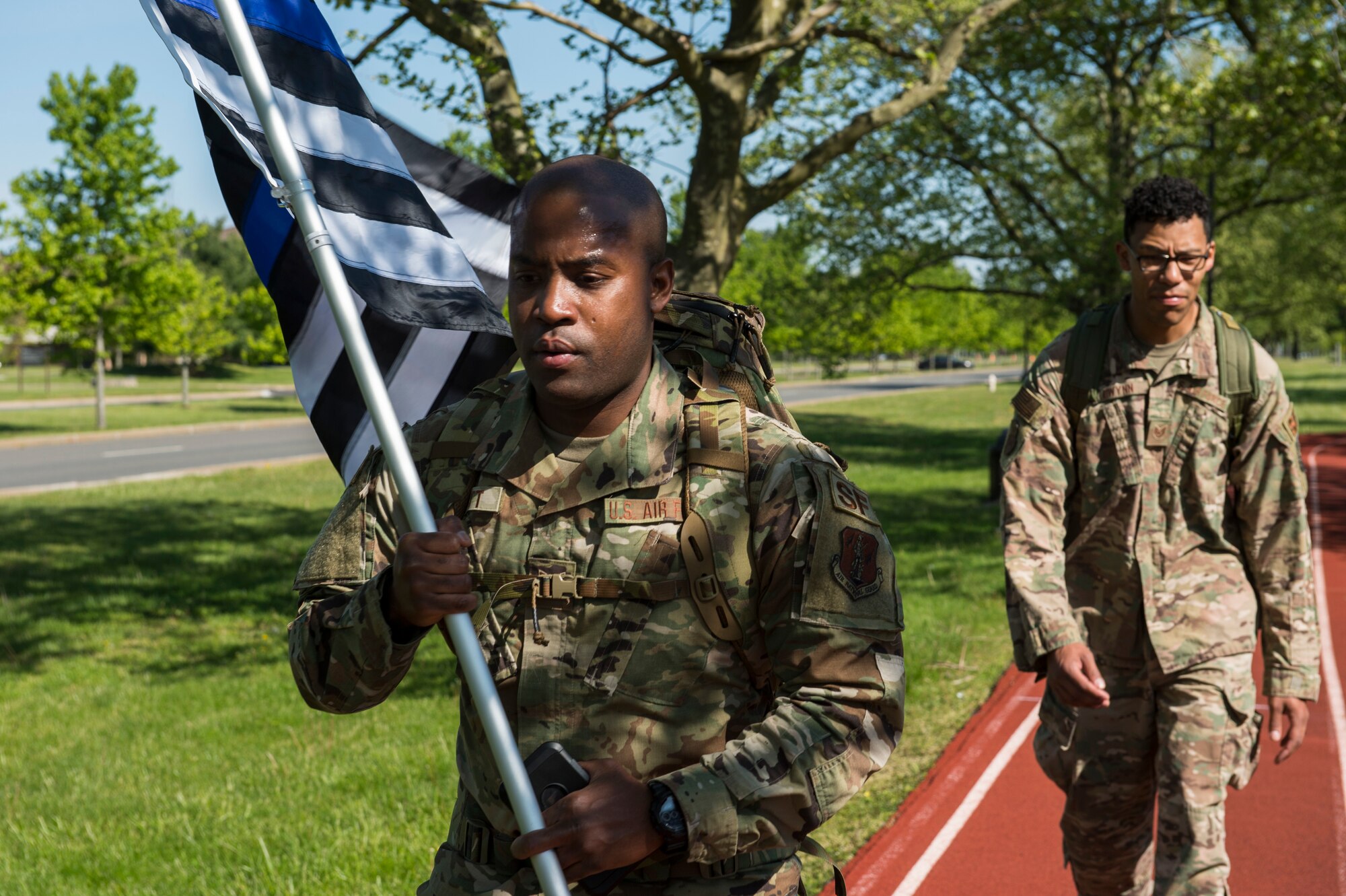 Tech. Sgt. Rafiq Pickett, left, 108th Wing Security Forces member and Tech. Sgt. Gwynn, right, 87th Air Base Wing Security Forces member, maintain six feet of distance while participating in a 24-hour ruck march May 15, 2020 at Joint Base McGuire-Dix-Lakehurst, N.J. The ruck march is an annual event that takes place during police week to remember fallen defenders. (U.S. Air Force photo by Staff Sgt. Sarah Brice)