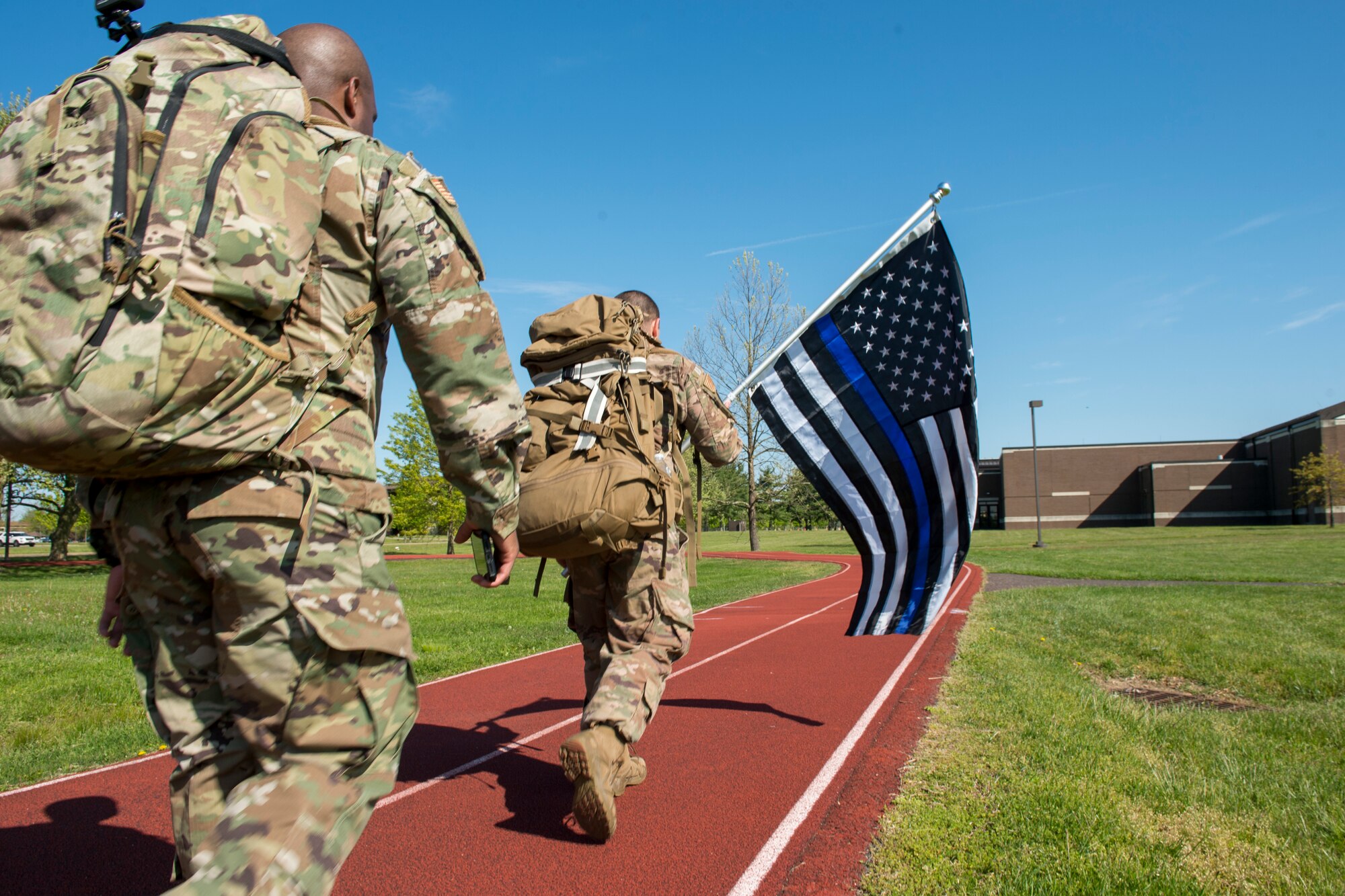 Security Forces Airmen run a lap around a fitness track as they take part in a 24-hour ruck march to honor fallen defenders May 15, 2020 at Joint Base McGuire-Dix-Lakehurst, N.J. Airmen volunteer to take shifts and keep the march going until 9 a.m. eastern standard time the following day. (U.S. Air Force photo by Staff Sgt. Sarah Brice)