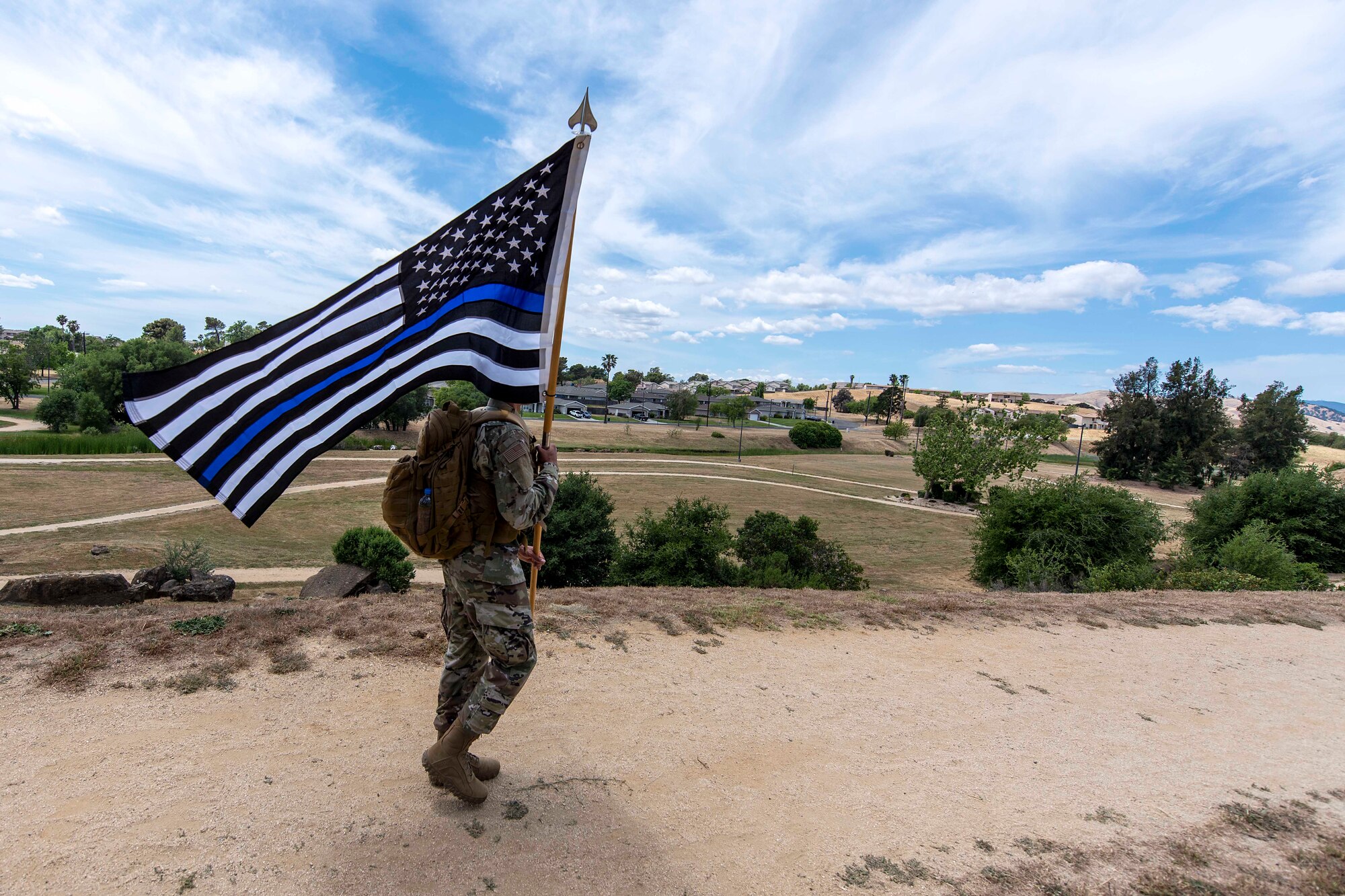 Photo of a security member walking with a guidon.