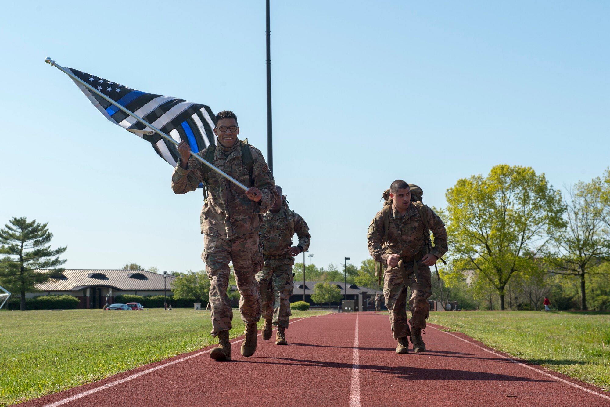Photo of Security Forces members marching on a track.