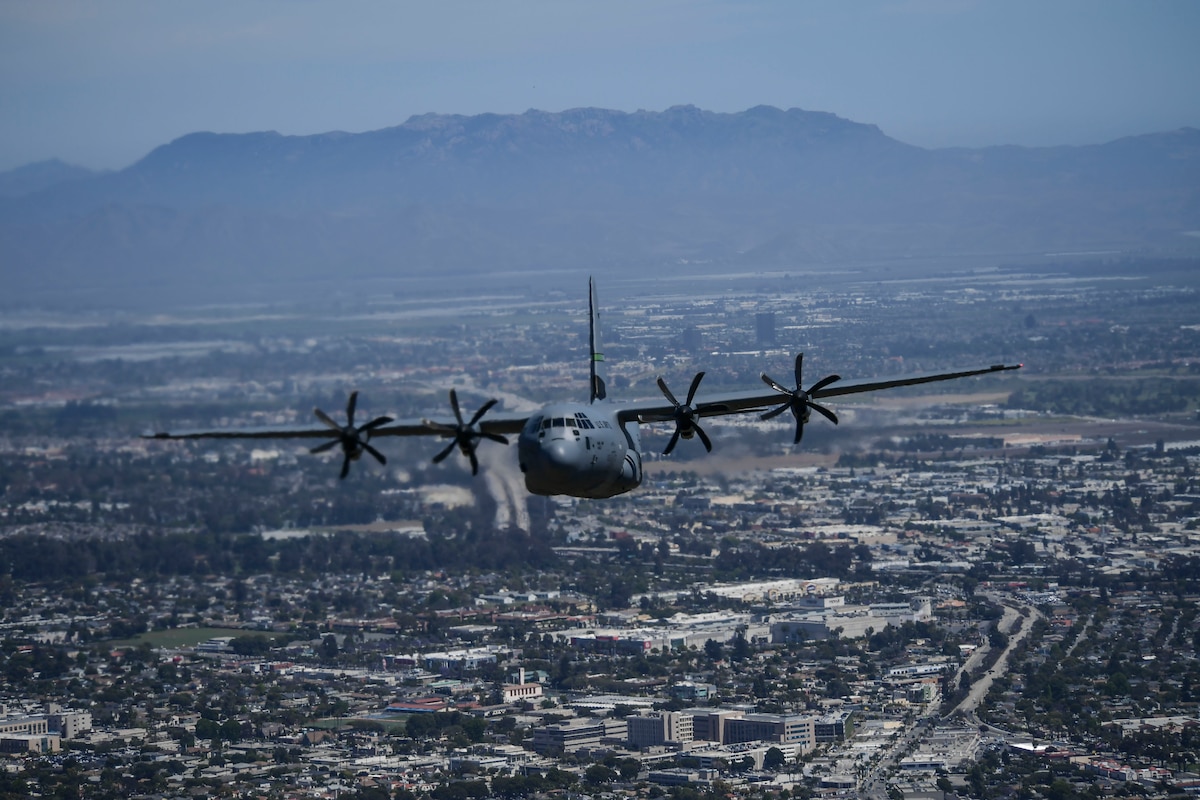 An Image of a Military C-130J Super Hercules aircraft flying over the city of Ventura County.