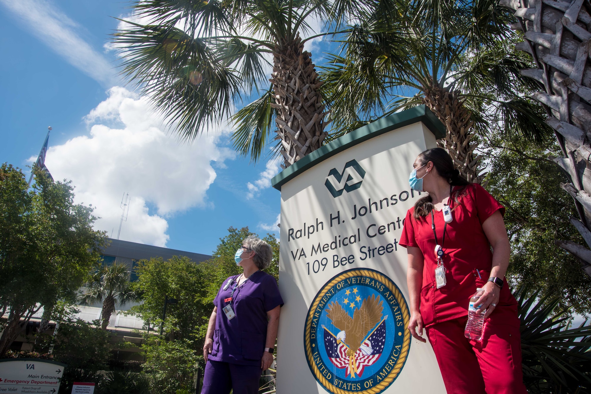 April Cheesebourough and Christina Schenk, VA employees and Air Force spouses, await a flyover saluting healthcare workers in the fight against COVID-19, May 15, 2020, at Ralph H. Johnson VA Medical Center in Charleston, South Carolina. Joint Base Charleston Airmen from the 315th Airlift Wing and 437th Airlift Wing, came together to train during this salute to healthcare workers that flew over several Charleston medical centers.