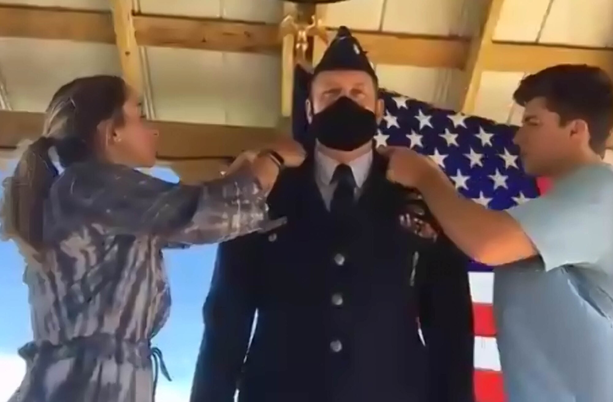 Col. William Roff, newly named Readiness and Integration Organization Commander of Detachment 8, Stuttgart, Germany, has the colonel eagle pinned to his uniform by his daughter-in-law Nicole Roff, left, and son, Garrette Roff, right, May 15, 2020, via virtual video. The unit training assembly (UTA) was held virtually in May due to COVID-19