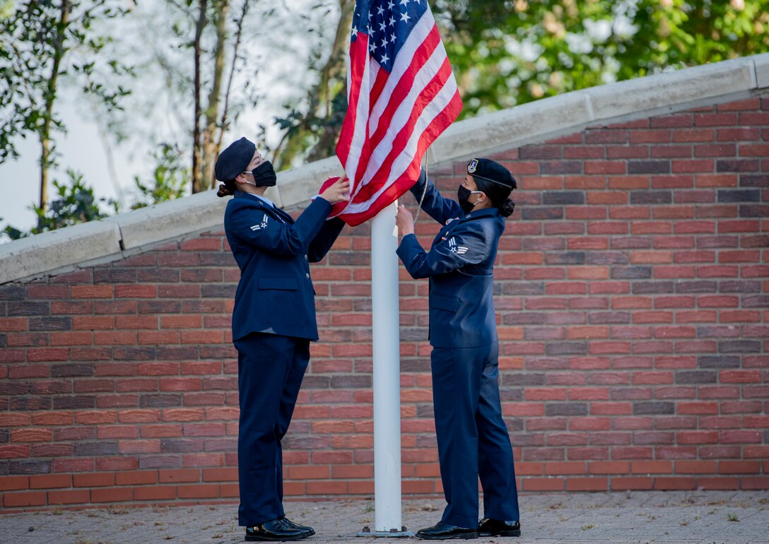 Airmen from the 48th Security Forces Squadron and the 100th SFS raise the U.S. flag during a morning reveille ceremony at Royal Air Force Lakenheath, England, May 11, 2020. The ceremony was held to mark the beginning of National Police Week, an annual time of remembrance to commemorate those law enforcement officers who have lost their lives in the line of duty. (U.S. Air Force photo by Airman 1st Class Jessi Monte)
