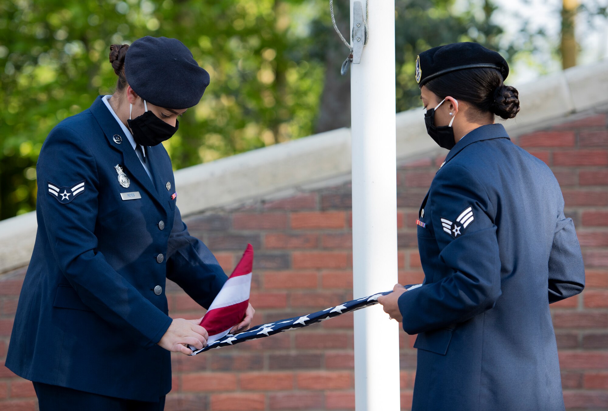 Airmen from the 48th Security Forces Squadron and the 100th SFS fold the U.S. flag in preparation for a morning reveille ceremony at Royal Air Force Lakenheath, England, May 11, 2020. The ceremony was held to mark the beginning of National Police Week, an annual remembrance to commemorate law enforcement officers who have lost their lives in the line of duty for the safety and protection of others. (U.S. Air Force photo by Airman 1st Class Jessi Monte)