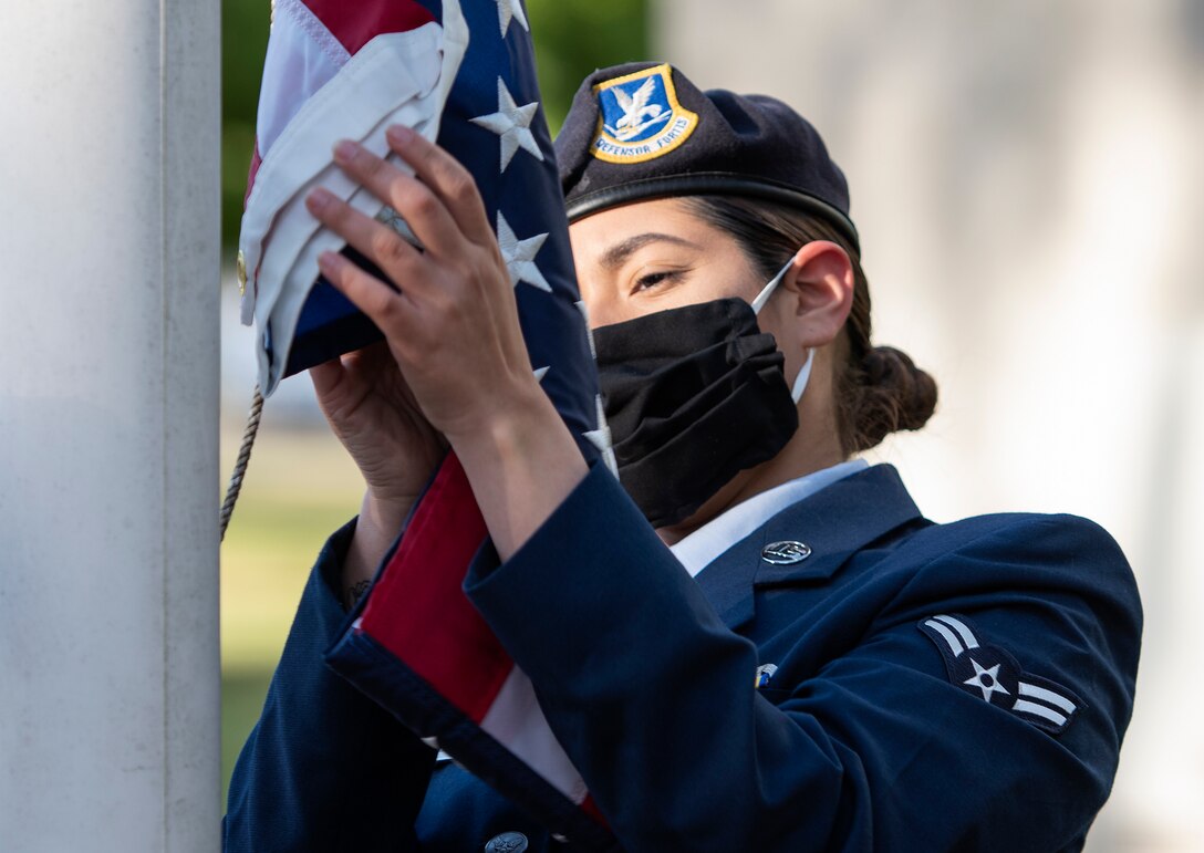 Airman 1st Class Gabbie Reyes, a member of the 100th Security Forces Squadron at Royal Air Force Mildenhall, prepares to raise the U.S. flag during a morning reveille ceremony at RAF Lakenheath, England, May 11, 2020. The ceremony was held to mark the beginning of National Police Week, an annual time of remembrance to commemorate law enforcement officers who have lost their lives in the line of duty for the safety and protection of others. (U.S. Air Force photo by Airman 1st Class Jessi Monte)