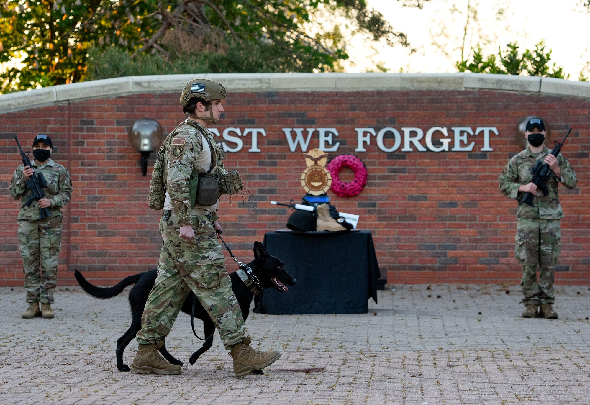 Tech Sgt. Alex Baron, a Military Working Dog trainer assigned to the 48th Security Forces Squadron, and his MWD Cchuy, act as a silent patrolling overwatch in remembrance of fallen Defenders during a candlelight vigil for National Police Week at Royal Air Force Lakenheath, England, May 14, 2020. In 1962, President John F. Kennedy signed Public Law 87-726 designating May 15 as Peace Officers' Memorial Day, and the week in which it falls as National Police Week. (U.S. Air Force photo by Airman 1st Class Jessi Monte)