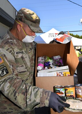 U.S. Army Sgt. Gregg Hierholzer, a motor transport operator with the 1113th Transportation Company, California Army National Guard, prepares food for distribution, May 6, 2020, at The Napa Storehouse, in Napa, California.