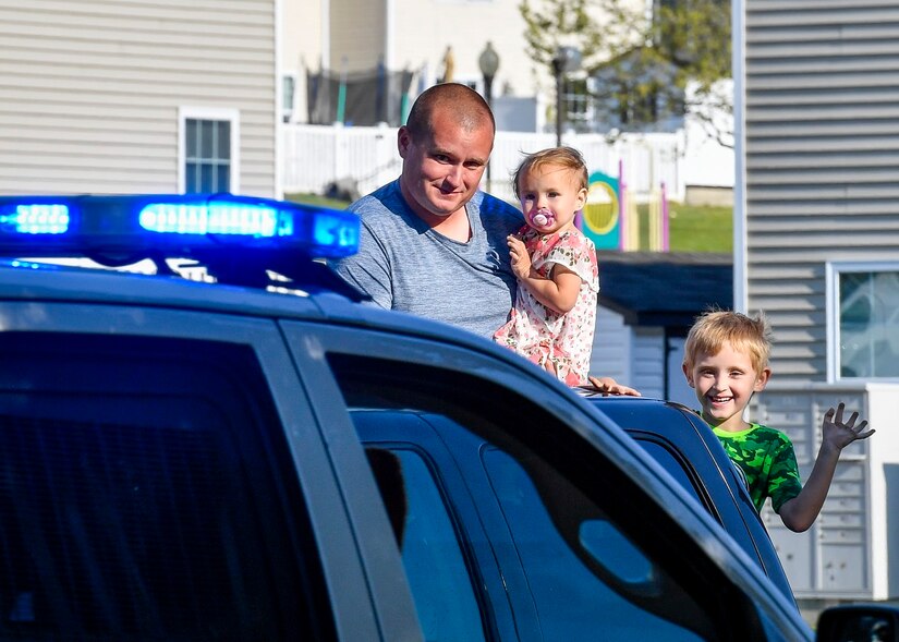 Photo of a family waving to a police car.
