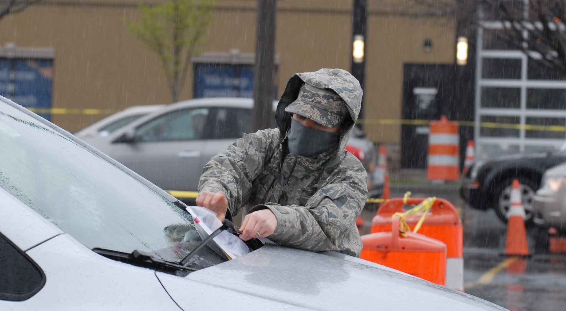 Air National Guard Tech. Sgt. Cara Sturdivant, assigned to the 107th Attack Wing, places paperwork under the windshield of a car at a COVID-19 mobile test site in Buffalo, New York, April 30. Members of the New York National Guard are supporting state agencies testing residents at 14 sites across New York.