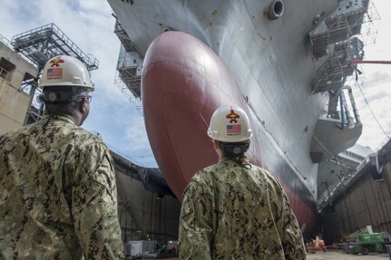 Rear Adm. Stephen Evans, left, commander of Carrier Strike Group 2 (CSG 2) and Rear Adm. Sara A. Joyner, right, take a tour of the aircraft carrier USS George H.W. Bush (CVN 77).