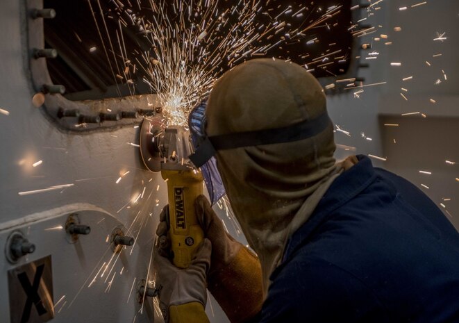 Hull Maintenance Technician 3rd Class Zachary Mayer, from Madison, Wisconsin, grinds a bolt aboard the aircraft carrier USS George H.W. Bush (CVN 77).