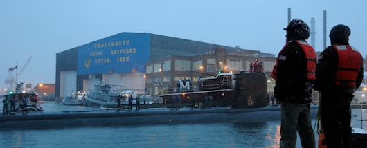 Line handlers stand at the ready to moor the Los Angeles-class attack submarine USS Miami (SSN 755) as the boat arrives at Portsmouth Naval Shipyard to begin an engineered overhaul period.