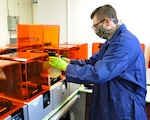 Oscar Savastio removes a completed swab batch from a 3-D printer