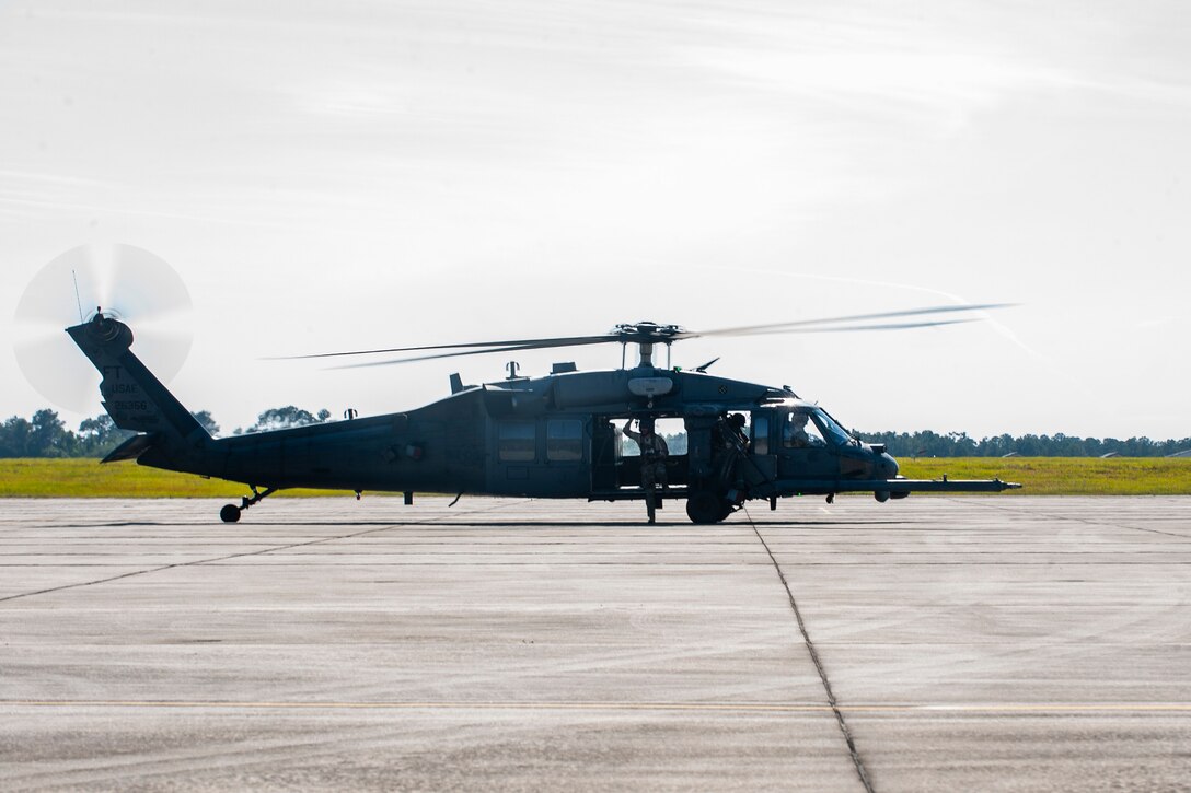 A photo of Airmen sitting in a helicopter.