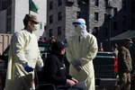 Members of the Vermont National Guard and employees of the University of Vermont Medical Center wheel a notional patient to a triage station as part of a Mass Casualty Exercise at the UVM Medical Center in Burlington, Vermont, April 15, 2020. The Vermont National Guard is working with the state of Vermont and emergency partners in a whole-of-government effort to flatten the curve during the COVID-19 pandemic.