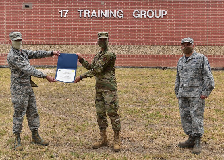 U.S. Air Force Col. Thomas Coakley, 17th Training Group commander, presents the 315th Training Squadron Student of the Month award to Airman 1st Class Nelson Tsai, 315th TRS student, at Brandenburg Hall on Goodfellow Air Force Base, Texas, May 15, 2020. The 315th TRS’ vision is to develop combat-ready intelligence, surveillance and reconnaissance professionals and promote an innovative squadron culture and identity unmatched across the U.S. Air Force. (U.S. Air Force photo by Staff Sgt. Chad Warren)