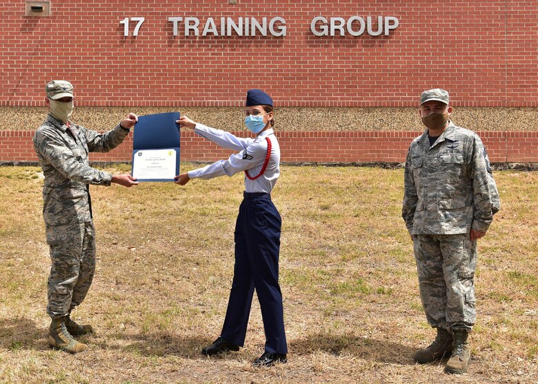 U.S. Air Force Col. Thomas Coakley, 17th Training Group commander, presents the 316th Training Squadron Student of the Month award to Airman 1st Class Alex Fuerte, 316th TRS student, at Brandenburg Hall on Goodfellow Air Force Base, Texas, May 15, 2020. The 316th TRS’ mission is to conduct U.S. Air Force, U.S. Army, U.S. Marine Corps, U.S. Navy and U.S. Coast Guard cryptologic, human intelligence and military training. (U.S. Air Force photo by Staff Sgt. Chad Warren)
