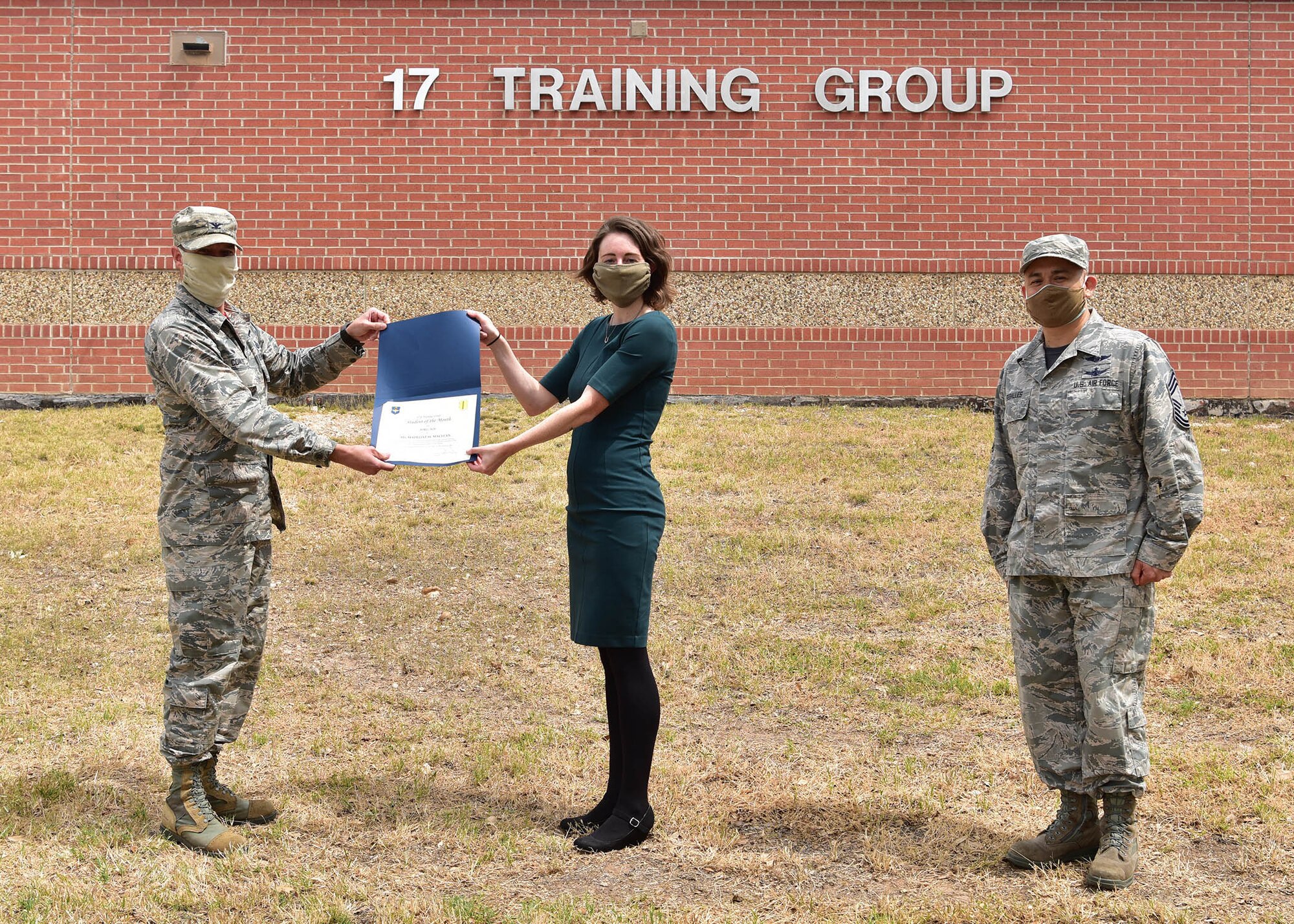 U.S. Air Force Col. Thomas Coakley, 17th Training Group commander, presents the 315th Training Squadron 14N Course Student of the Month award to Ms. Madeline Maclean, 315th TRS student, at Brandenburg Hall on Goodfellow Air Force Base, Texas, May 15, 2020. Military training leaders select top performers each month to be recognized by 17 TRG leadership for their hard work and leadership among their peers. (U.S. Air Force photo by Staff Sgt. Chad Warren)
