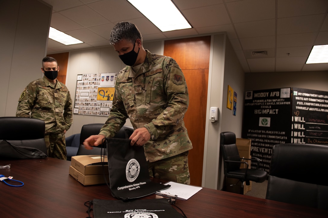 An Airman places gun locks into a bag
