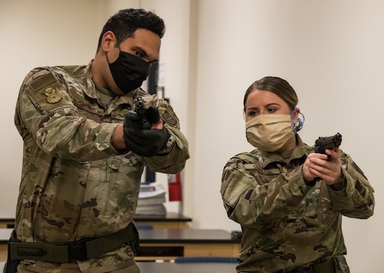 Staff Sgt. Jose Bracero-Camareno, 436th Security Forces Squadron combat arms instructor, teaches Airman 1st Class Kaleigh O’Hara, 436th Comptroller Squadron budget analyst, proper M9 sight alignment May 13, 2020, at Dover Air Force Base, Delaware. Bracero-Camareno instructed O’Hara and other Team Dover members on the M9 prior to their upcoming deployment or permanent change of station. (U.S. Air Force photo by Roland Balik)