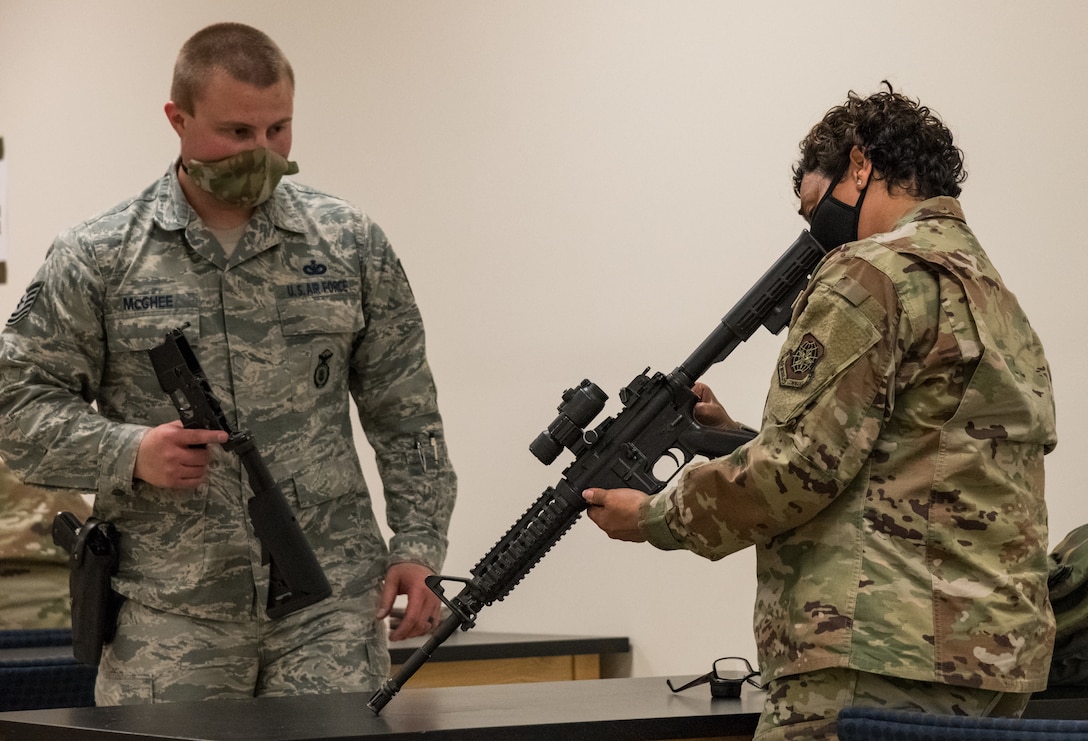 Tech. Sgt. Don McGhee, 436th Security Forces Squadron combat arms instructor, watches Senior Master Sgt. Warrell Shanklin, 436th Comptroller Squadron superintendent, assemble her M4 during Combat Arms Training and Maintenance class May 13, 2020, at Dover Air Force Base, Delaware. Team Dover members received M4 and M9 weapons training prior to their upcoming deployment or permanent change of station. A shelter-in-place order was issued in mid-March to help mitigate the spread of COVID-19. (U.S. Air Force photo by Roland Balik)