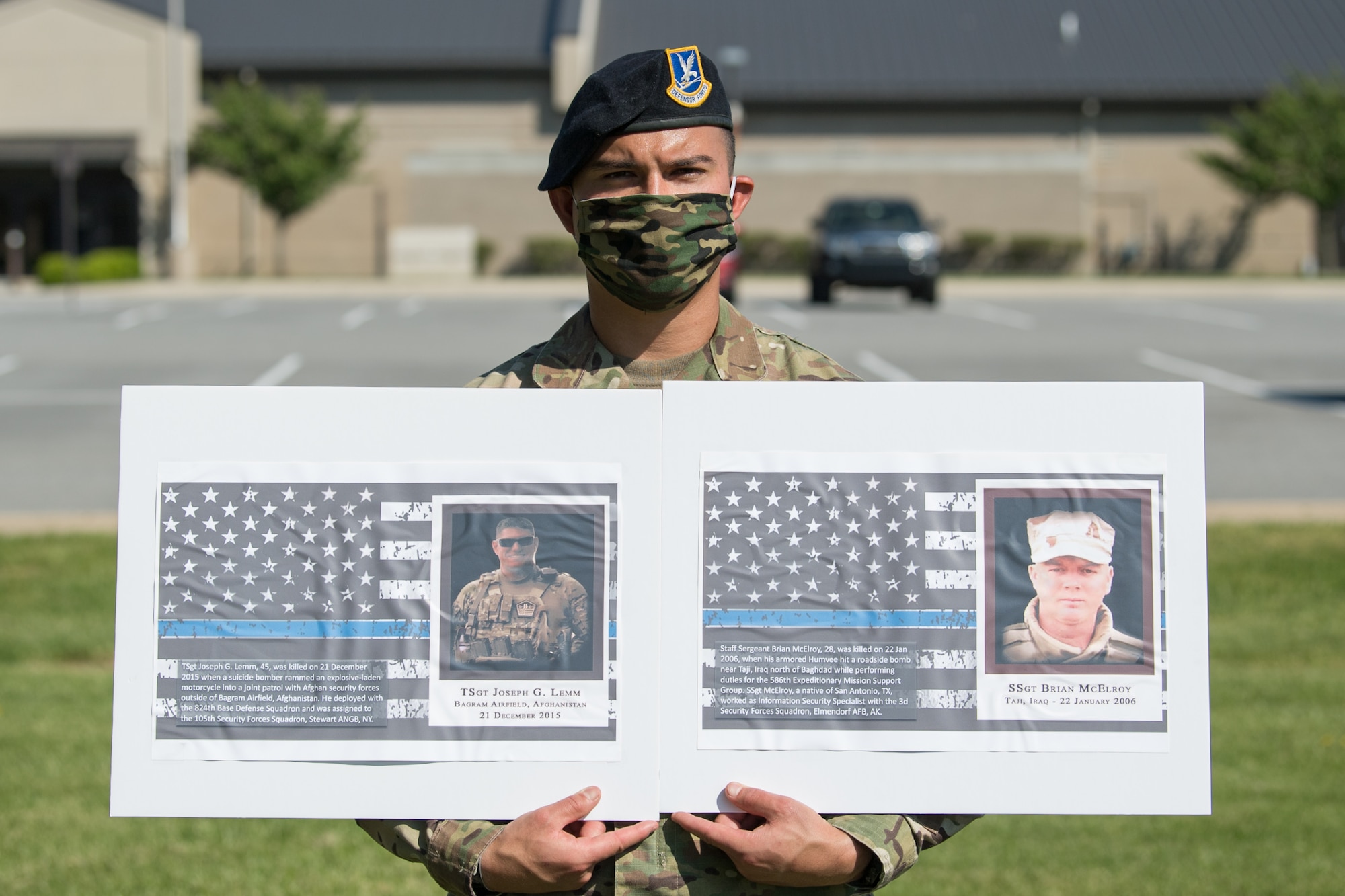 Senior Airman Vincent Leal, 436th Security Forces Squadron Raven team leader, holds photos of two fallen defenders during a retreat ceremony on Peace Officers Memorial Day May 15, 2020, at Dover Air Force Base, Delaware. The ceremony commemorating fallen military and civilian law enforcement officers marked the end of National Police Week 2020. (U.S. Air Force photo by Mauricio Campino)