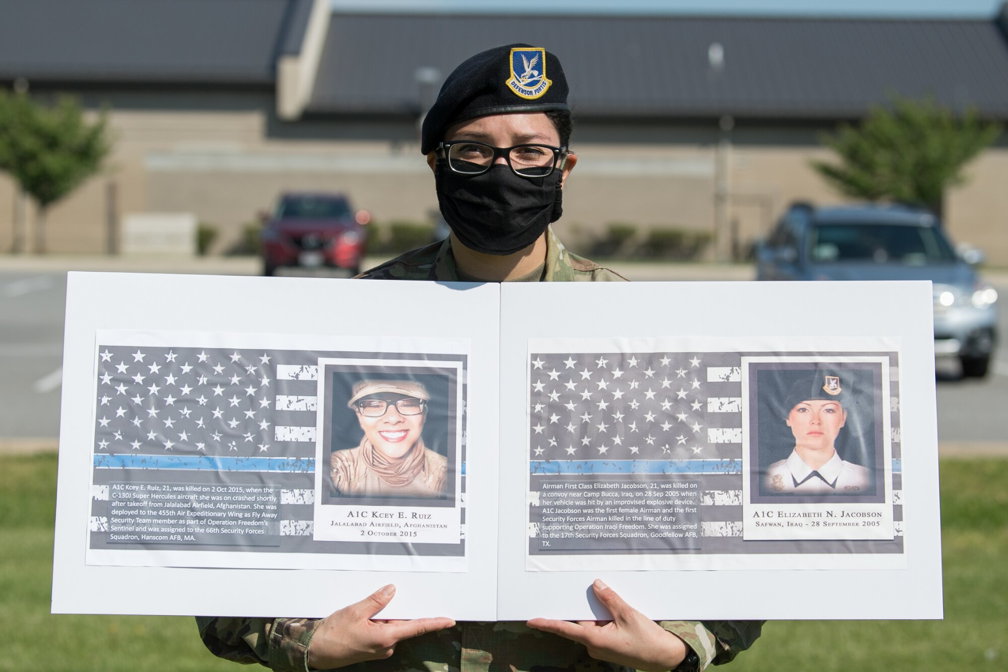 Senior Airman Theresa Braack, 436th Security Forces Squadron military working dog handler, holds photos of two fallen defenders during a retreat ceremony on Peace Officers Memorial Day May 15, 2020, at Dover Air Force Base, Delaware. The ceremony commemorating fallen military and civilian law enforcement officers marked the end of National Police Week 2020. (U.S. Air Force photo by Mauricio Campino)