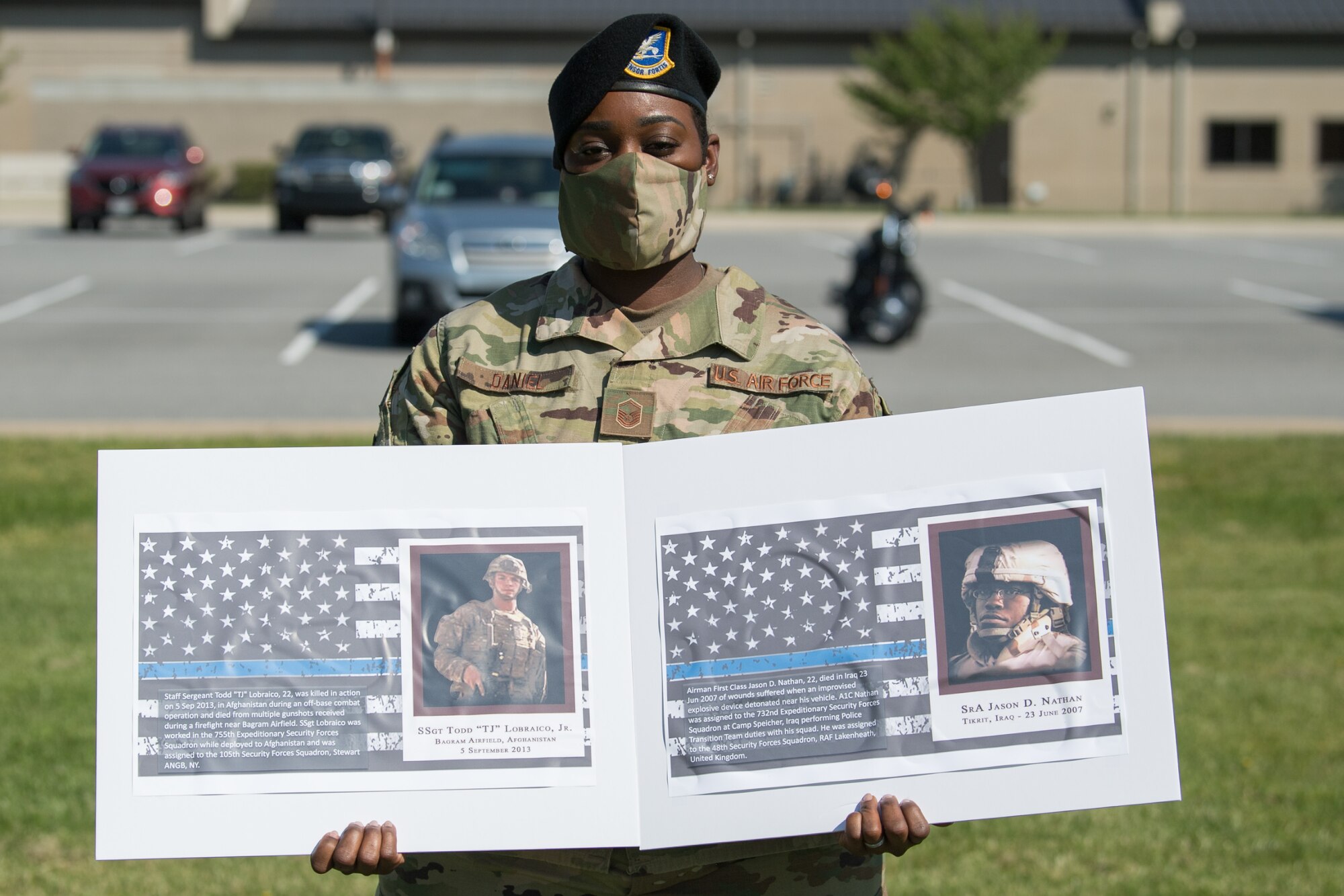 Master Sgt. Ashley Daniel, 436th Security Forces Squadron flight chief, holds photos of two fallen defenders during a retreat ceremony on Peace Officers Memorial Day May 15, 2020, at Dover Air Force Base, Delaware. The ceremony commemorating fallen military and civilian law enforcement officers marked the end of National Police Week 2020. (U.S. Air Force photo by Mauricio Campino)