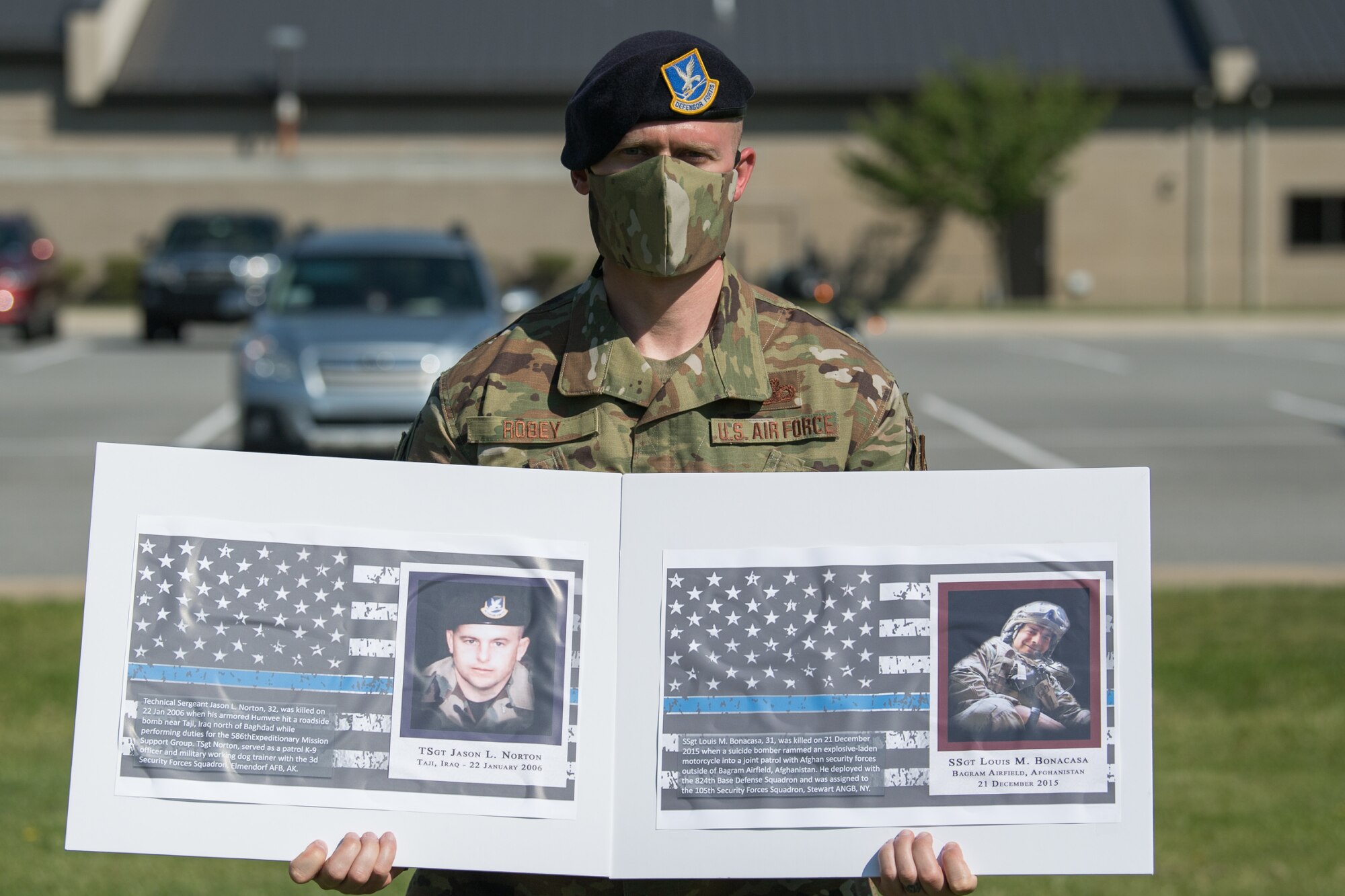 Master Sgt. Jeffrey Robey, 436th Security Forces Squadron noncommissioned officer in charge of investigations, holds photos of two fallen defenders during a retreat ceremony on Peace Officers Memorial Day May 15, 2020, at Dover Air Force Base, Delaware. The ceremony commemorating fallen military and civilian law enforcement officers marked the end of National Police Week 2020. (U.S. Air Force photo by Mauricio Campino)