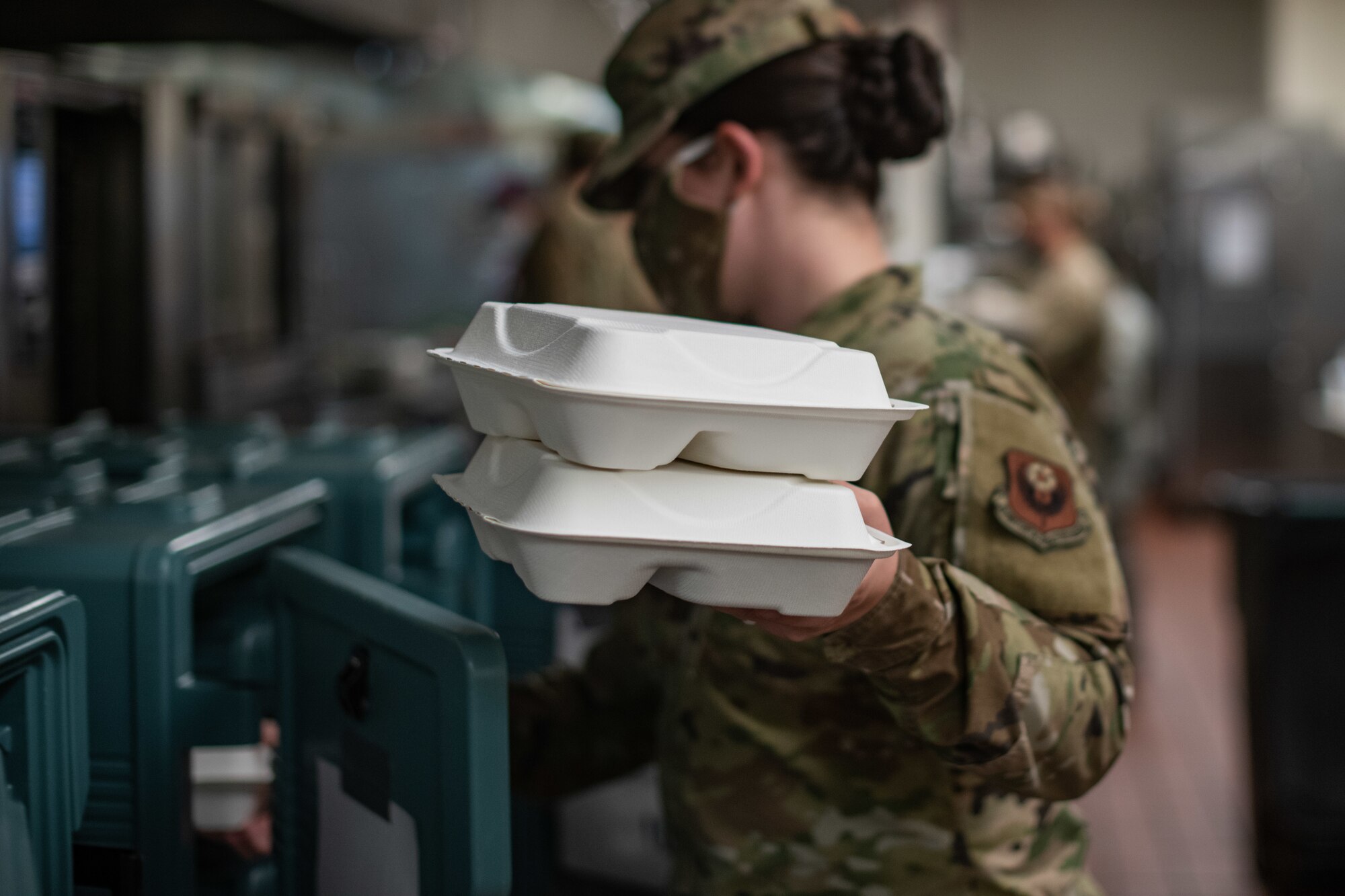 Staff Sgt. Megan Bales, a food services specialist assigned to the 27th Special Operations Force Support Squadron, loads meal containers into insulated boxes at the Pecos Trail Dining Facility on Cannon Air Force Base, N.M, May 15, 2020. The meals were prepared for delivery to Airmen quarantined on the base due to the COVID-19 pandemic. (U.S. Air Force photo by Senior Airman Maxwell Daigle)