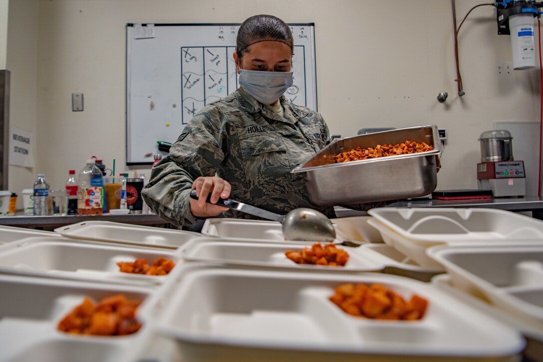 Senior Airman Andrea Hollis, a food services specialist assigned to the 27th Special Operations Force Support Squadron, ladles food into meal containers for quarantined Airmen at the Pecos Trail Dining Facility on Cannon Air Force Base, N.M., May 15, 2020. The 27 SOFSS services flight has been preparing meals for Airmen quarantined to the base while continuing normal operations at the Pecos Trail DFAC. (U.S. Air Force photo by Senior Airman Maxwell Daigle)