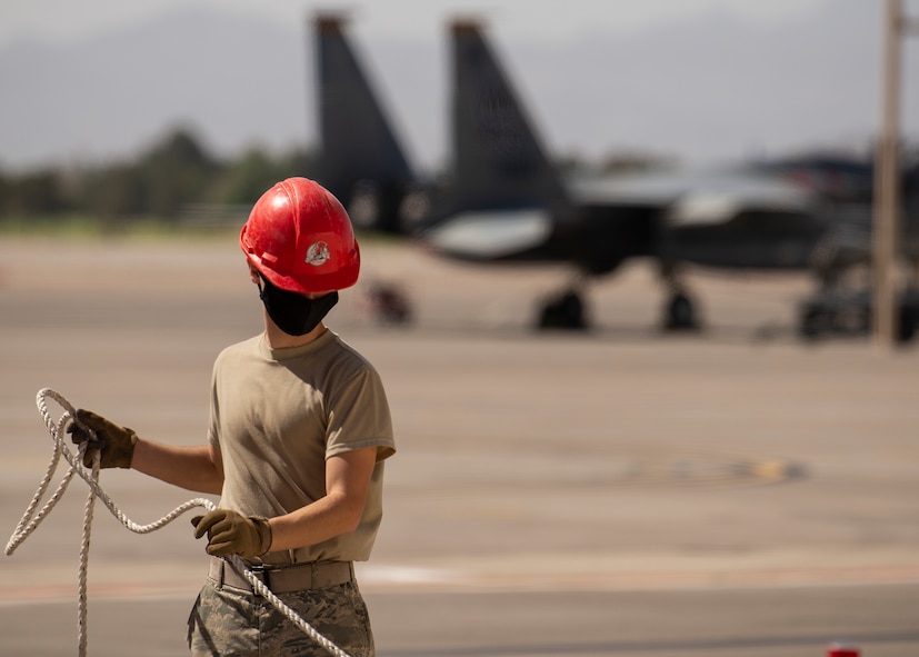 A RED HORSE Airman bundles up rope.