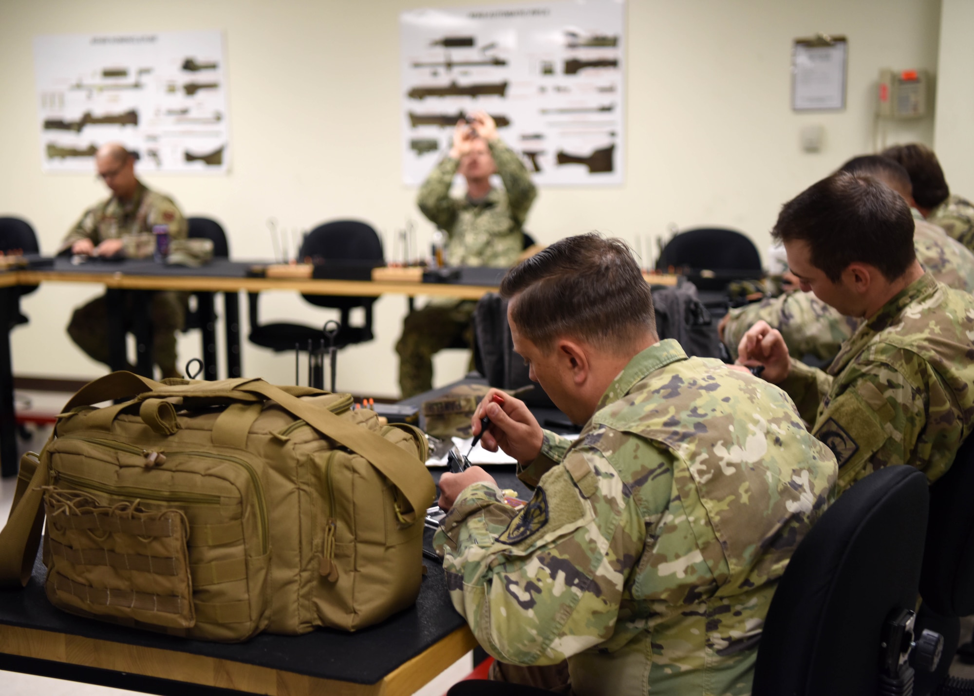 Military members of Goodfellow Air Force Base disassemble their weapons and check them before reassembling them and bringing the Berretta M9s to the range during the Excellence in Competition pistol match on Goodfellow Air Force Base, Texas, May 15, 2020. Combat arms instructors led members through the steps to check their weapons and get used to them before bringing them on the range. (U.S. Air Force photo by Airman 1st Class Ethan Sherwood)