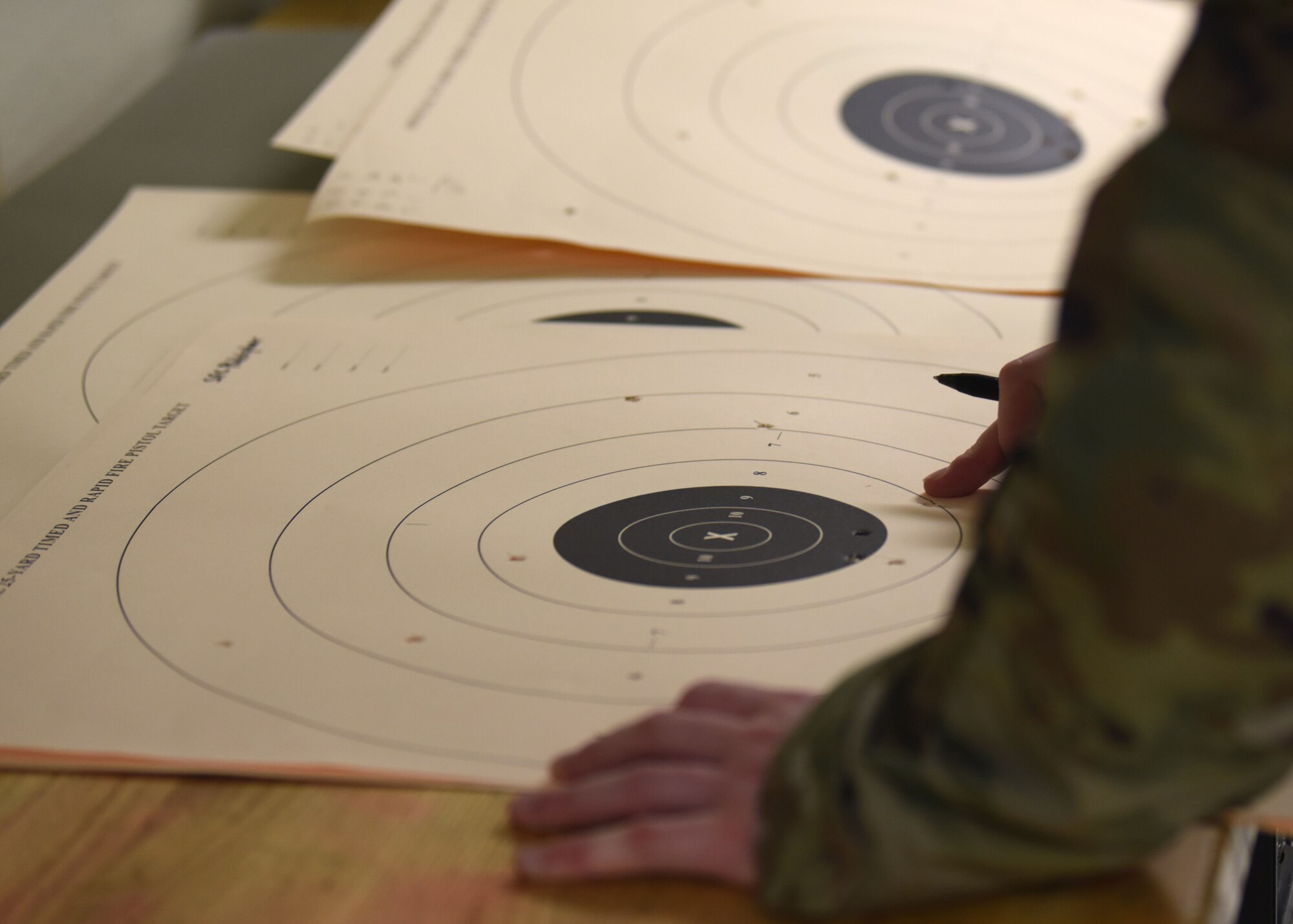 A combat arms instructor scores a target during the Excellence in Competition pistol match on Goodfellow Air Force Base, Texas, May 15, 2020. The only shots that counted towards winning the competition were those within the seven-point line and inward. (U.S. Air Force photo by Airman 1st Class Ethan Sherwood)