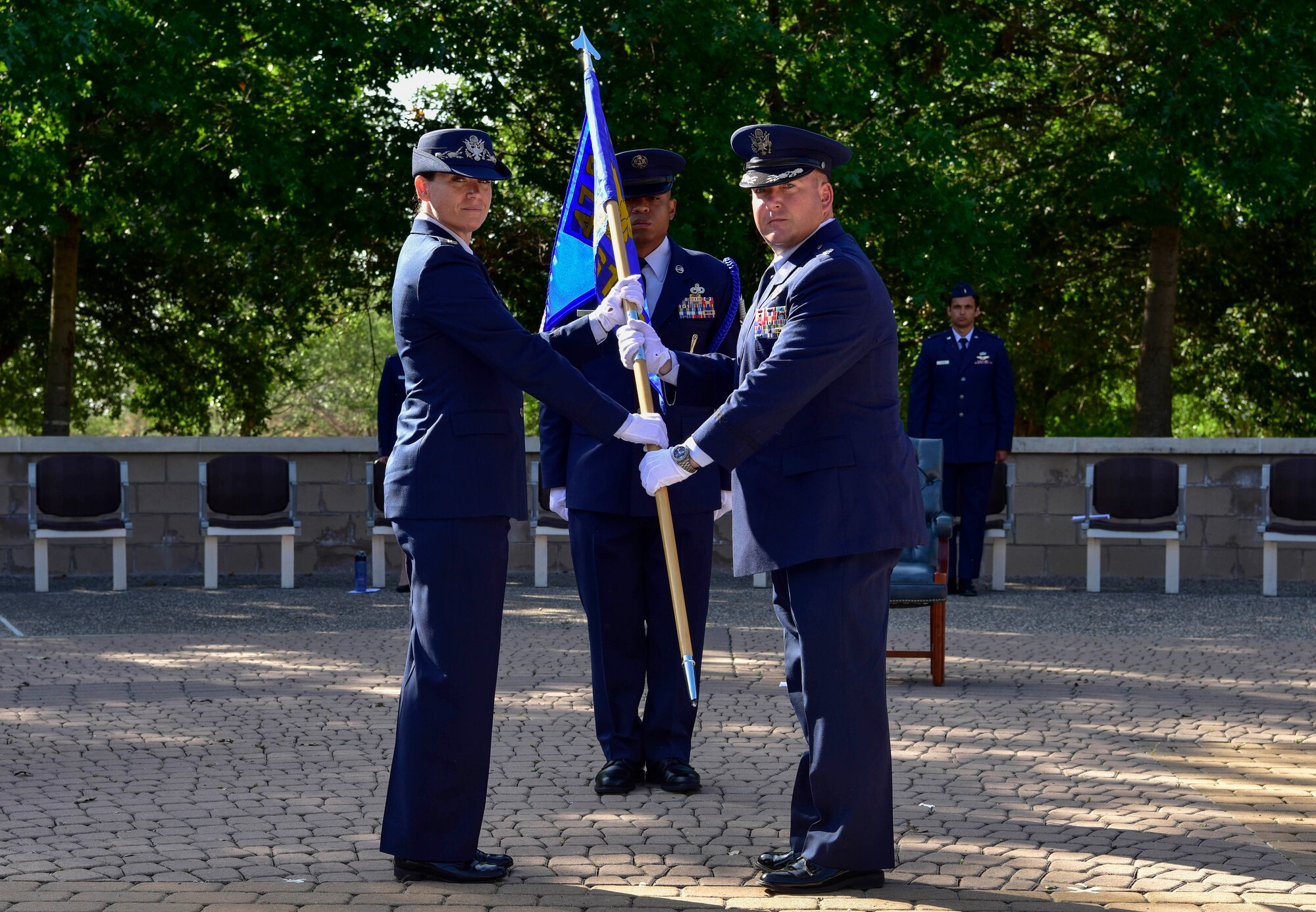 Col. Carey Jones, 47th Operations Group commander, passes a guidon to the new commander of the 47th Student Squadron, Lt. Col. Christopher Best, during a change of command ceremony at Laughlin Air Force Base, Texas, May 18, 2020. The passing of the guidon represents a formal transfer of authority and responsibility from one commander to the next. (U.S. Air Force photo by Senior Airman Marco A. Gomez)