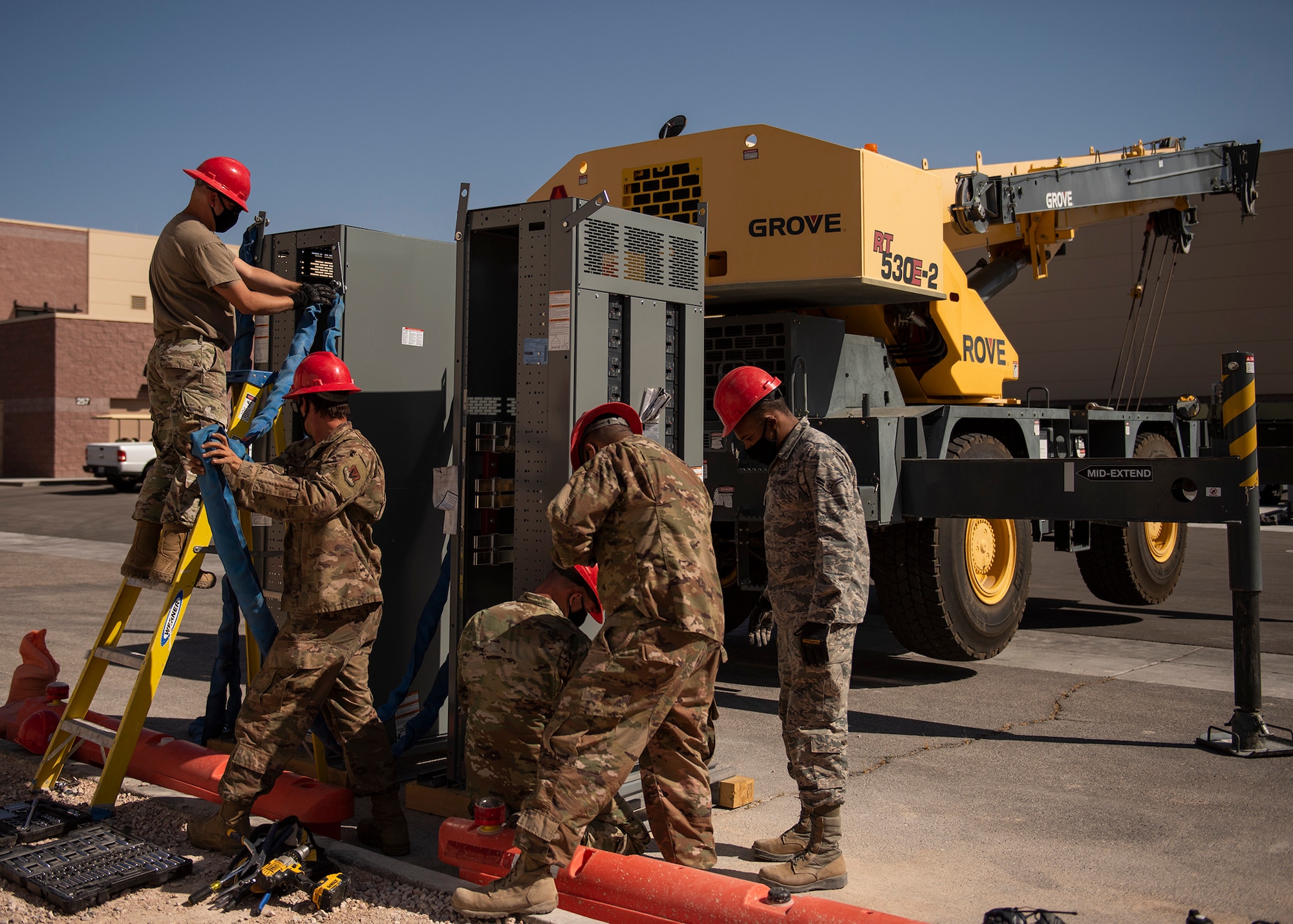 Five RED HORSE Airmen prepare a gearbox to be lifted by a 30-ton crane.